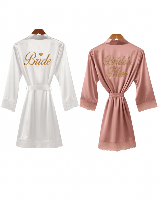 Bata de satín unitalla con frase bordada en la espalda y encaje en mangas y bastilla.