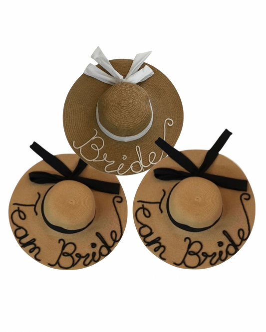 Sombrero playero de ala ancha con listón con moño en el centro y frase a mano de cordón.