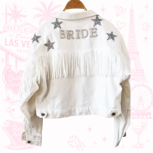 Temática Vegas. Chamarra de mezclilla blanca con barbas en la espalda con estrellas y frase de BRIDE de cristales.                                    Entrega de 15 a 20 días hábiles.